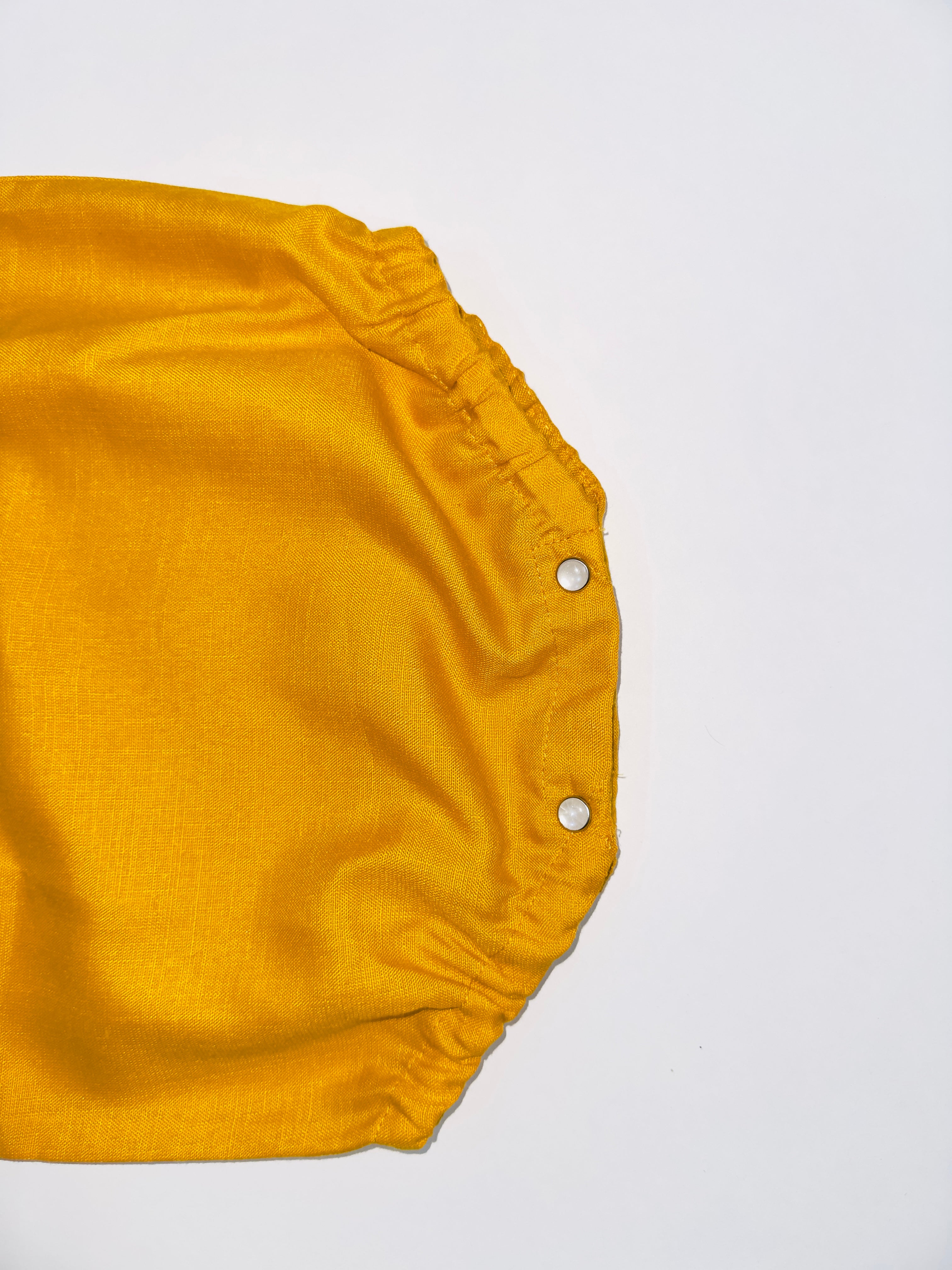 Classic Mustard Buttoned Baby Romper with Wooden Buttons and Snap Closures.