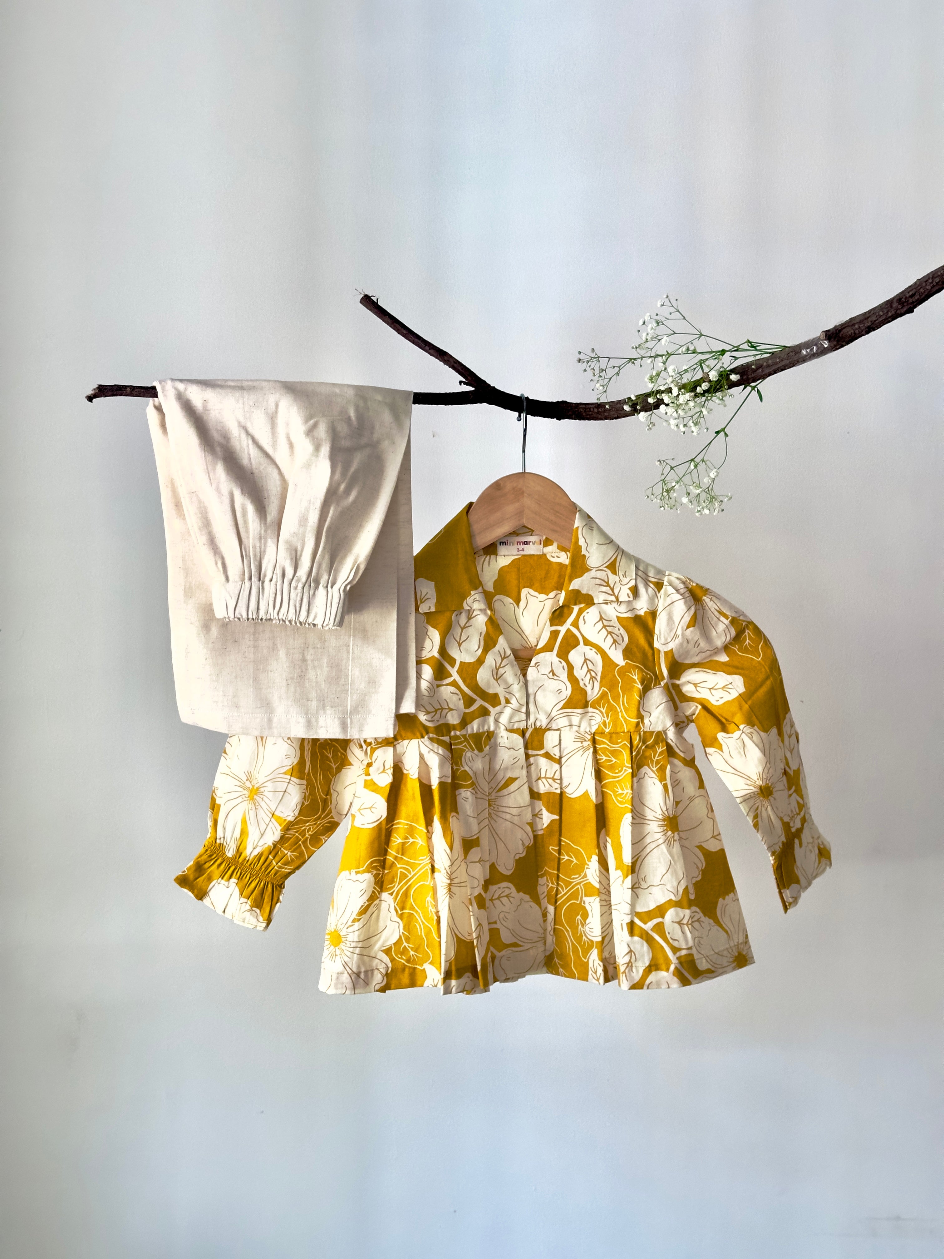 Yellow floral blouse on a hanger against a white background
Cotton baby girl co-ord set with floral print