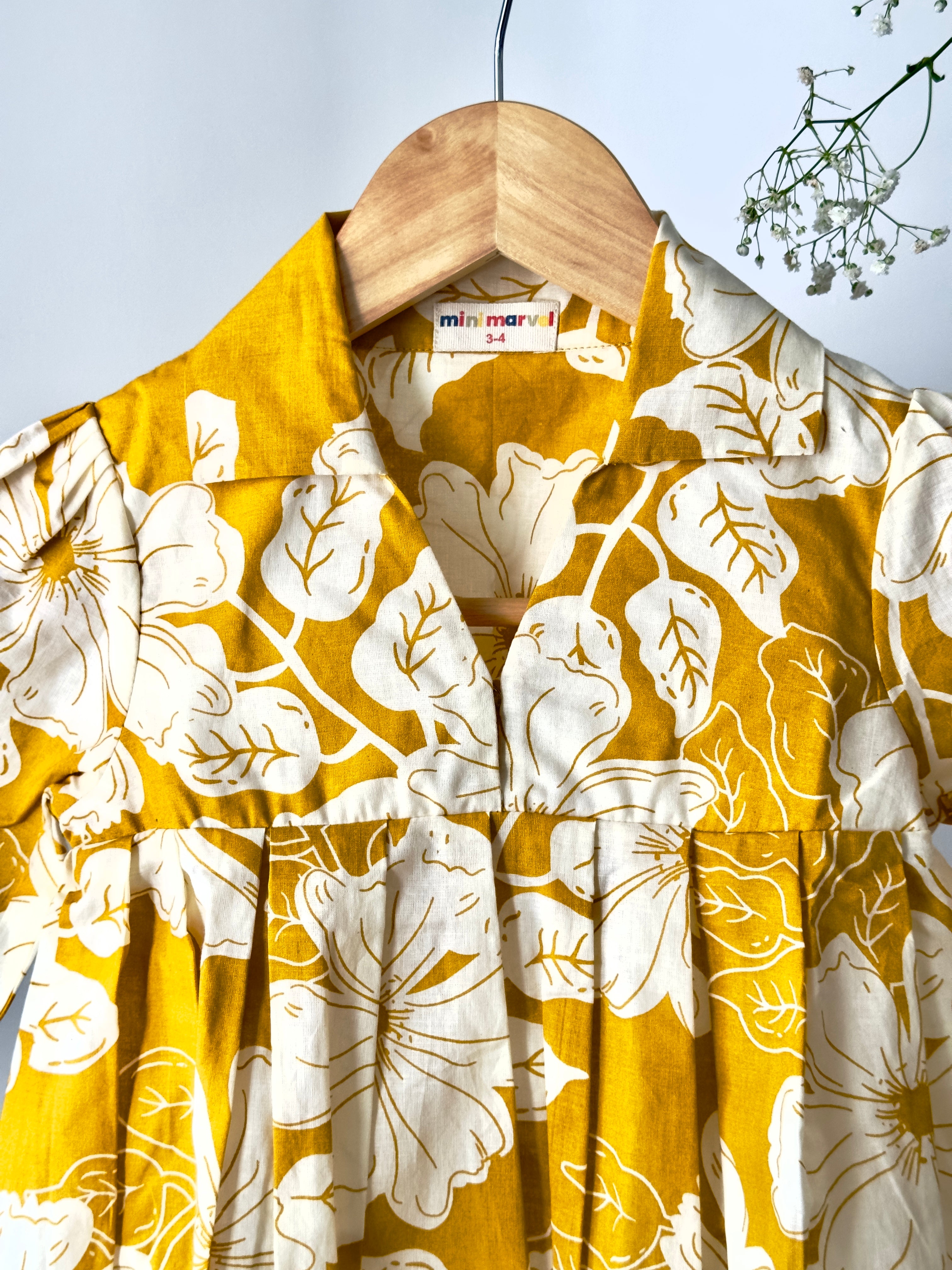 Yellow shirt with white floral pattern on a wooden hanger against a light background
Cotton baby girl co-ord set with floral print