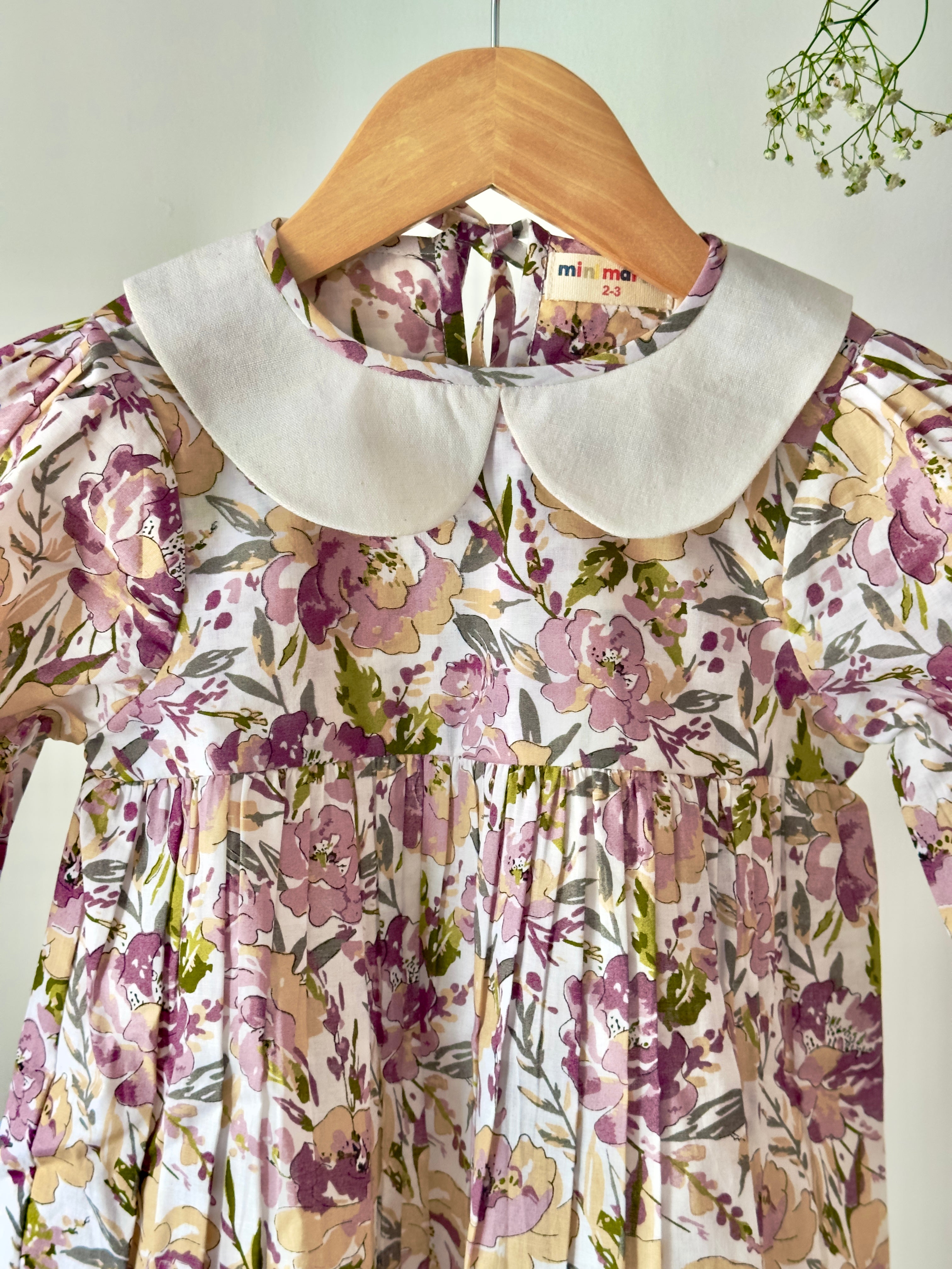 Floral pastel cotton dress with vintage collar displayed on hanger