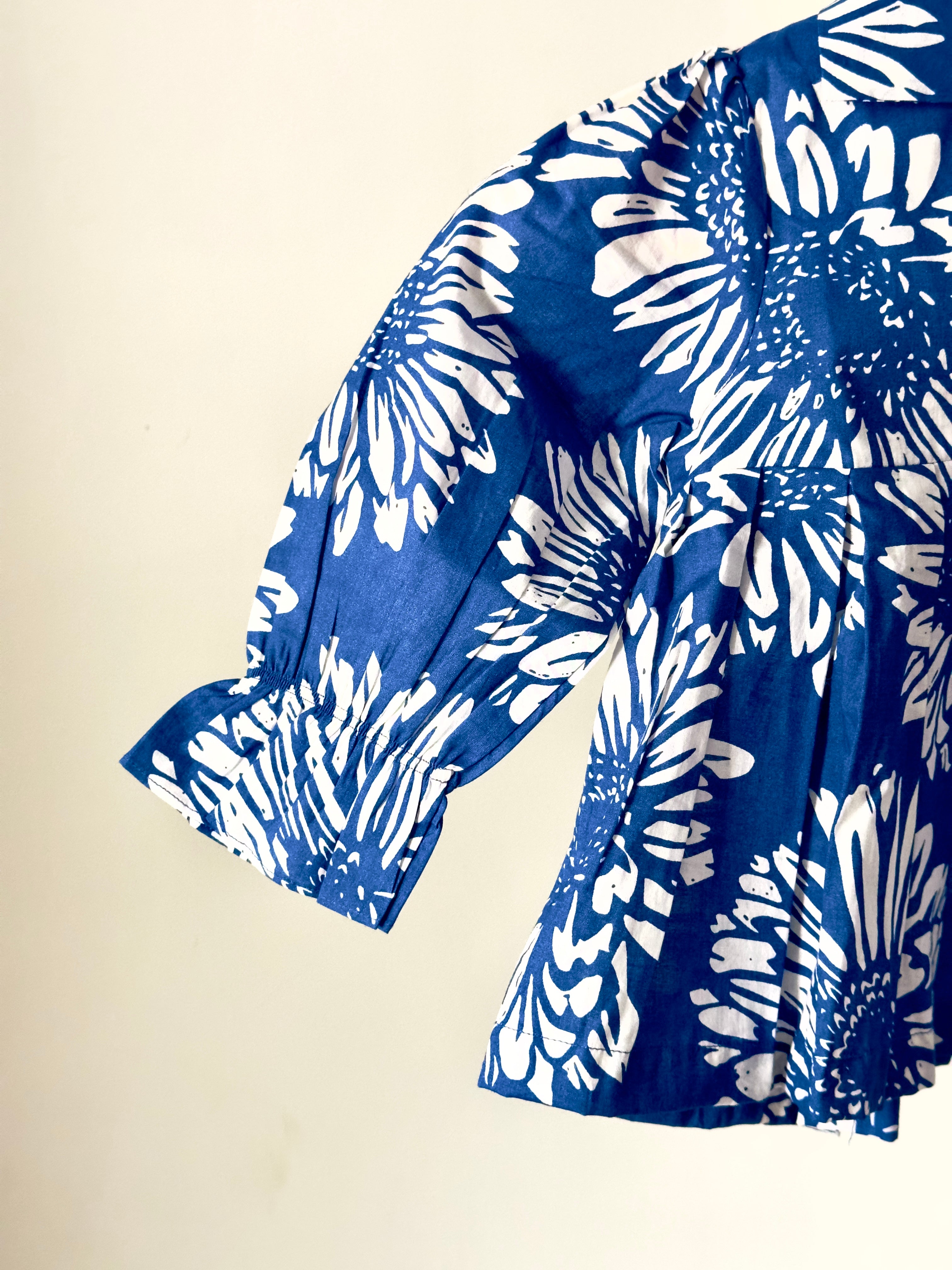 Blue and white floral patterned blouse on a beige background
Baby girl matching outfit set in blue and cream