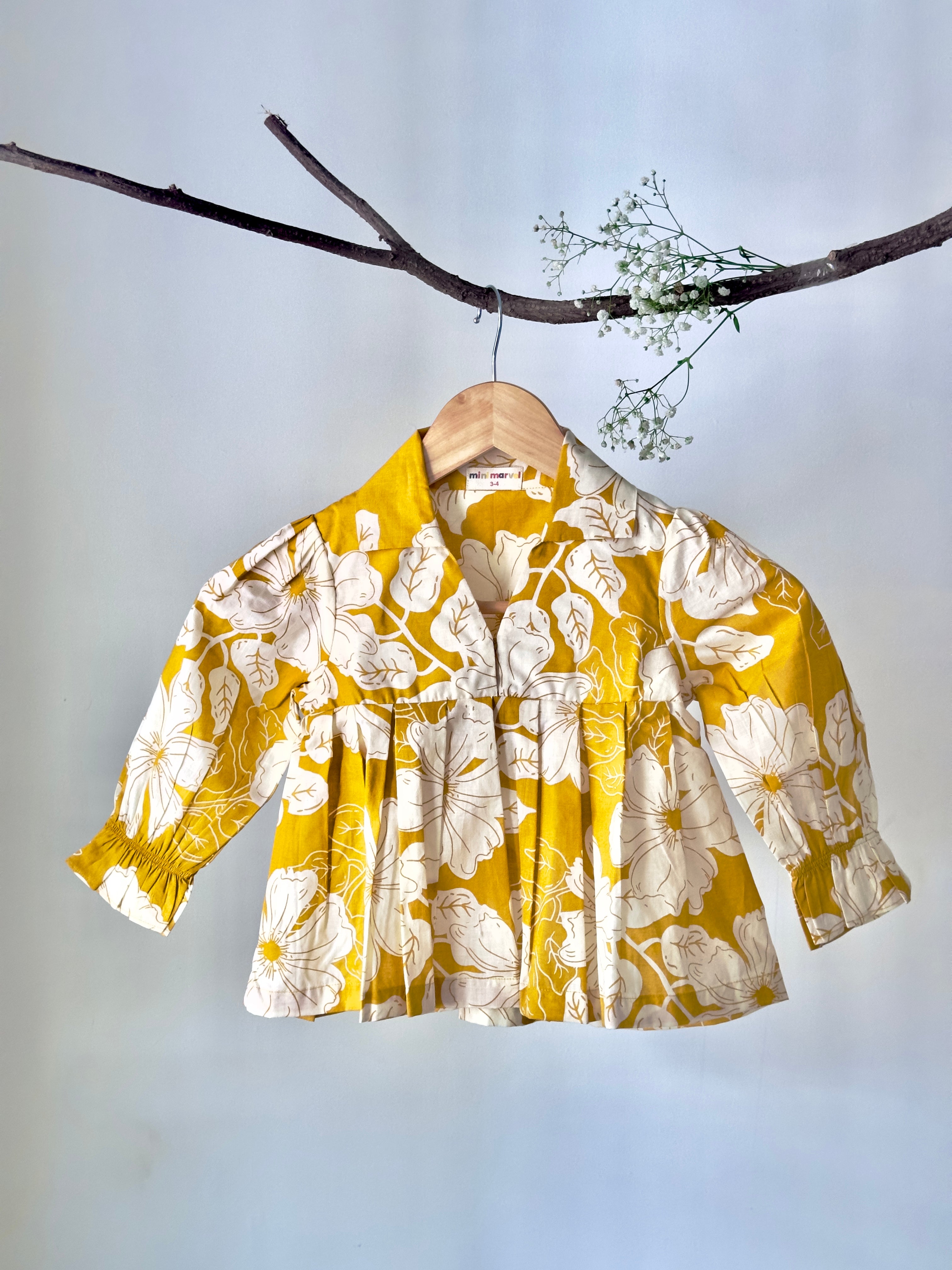 Yellow floral blouse on a hanger against a light gray background

Cotton baby girl co-ord set with floral print